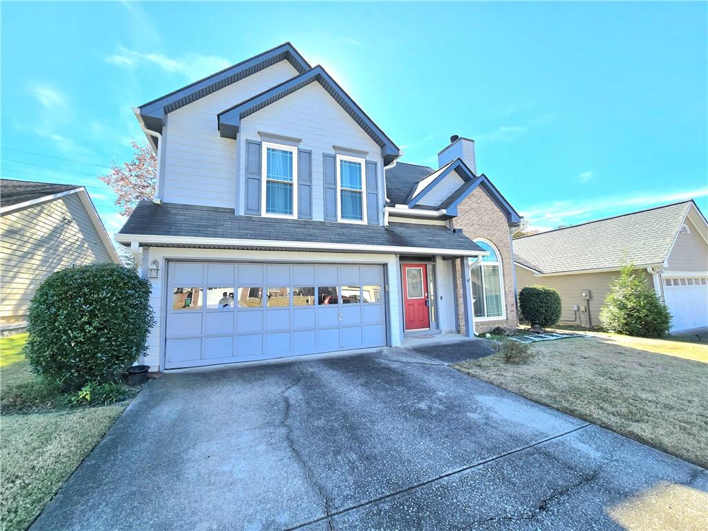 a view of a house with a yard and garage