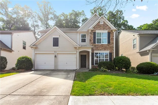 a front view of a house with a yard and garage