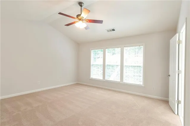 an empty room with a window and a fan