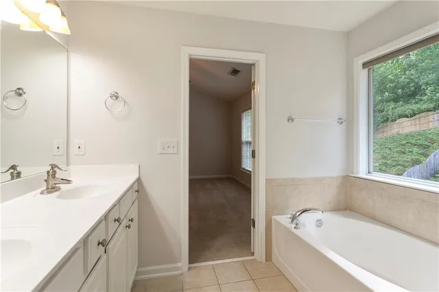 a bathroom with a tub a sink and a mirror