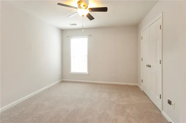an empty room with a window and a fan