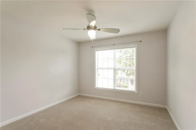 an empty room with a window and a fan