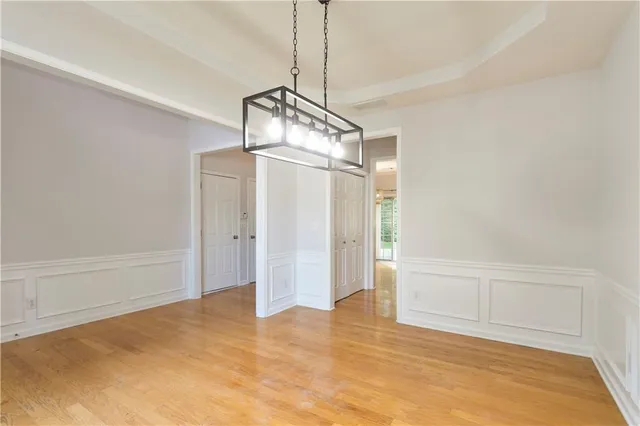 a view of empty room with wooden floor and ceiling fan