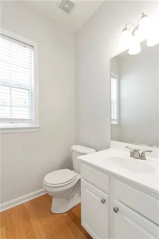 a bathroom with a sink a toilet and a window