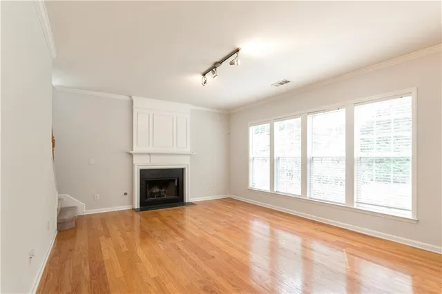 a view of an empty room with a window and fireplace