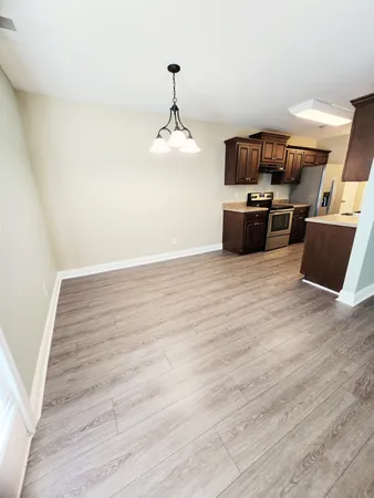 a view of a room with wooden floor and kitchen
