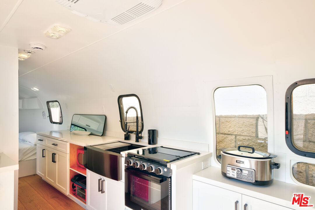 3020 Corral Canyon Road Malibu, CA 90265 - Photo 26 of 29 a kitchen with stainless steel appliances granite countertop a stove and a sink