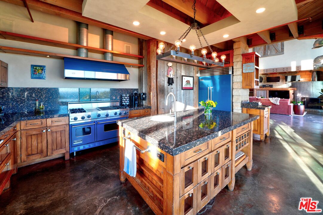 3020 Corral Canyon Road Malibu, CA 90265 - Photo 7 of 29 a kitchen with stainless steel appliances granite countertop a stove a sink and a white cabinets