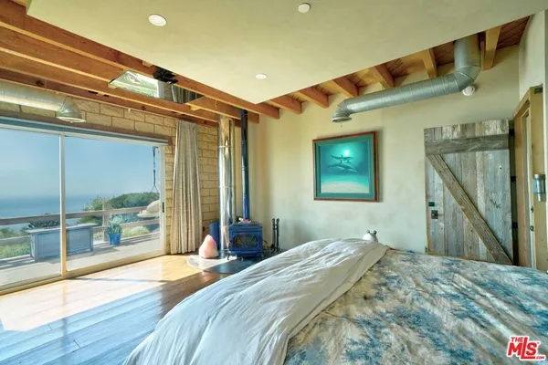 a bedroom with a bed and glass door