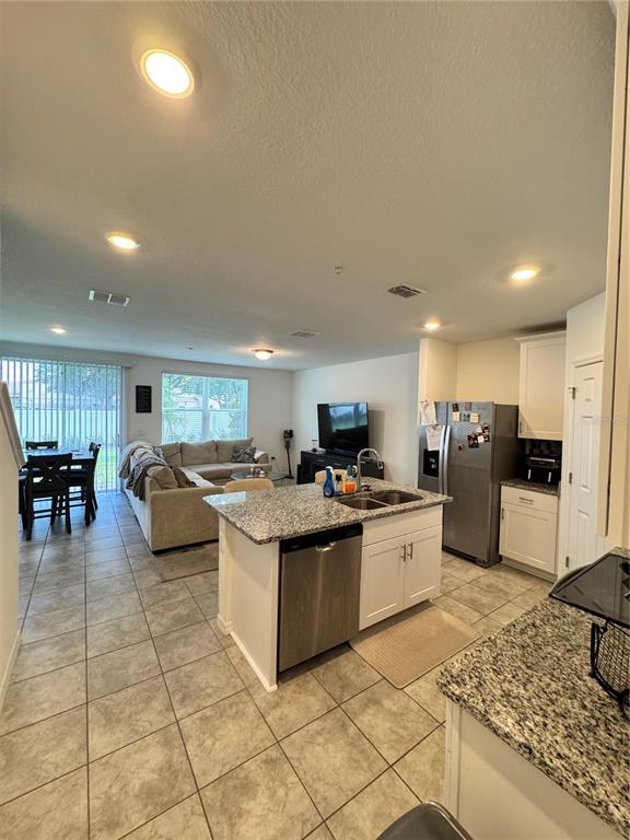 2089 Crape Jasmine Lane Orlando, FL 32824 - Photo 6 of 22 a kitchen with stainless steel appliances kitchen island granite countertop a sink and cabinets