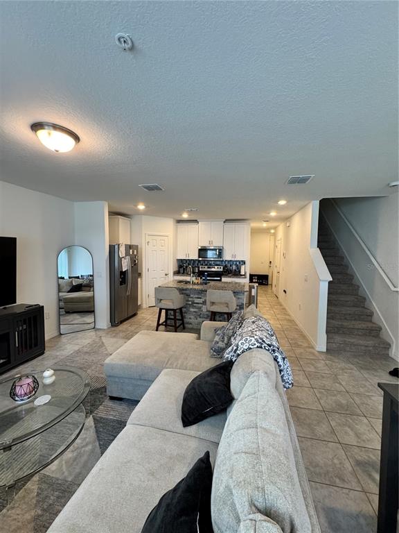 2089 Crape Jasmine Lane Orlando, FL 32824 - Photo 7 of 22 a living room with furniture and a flat screen tv