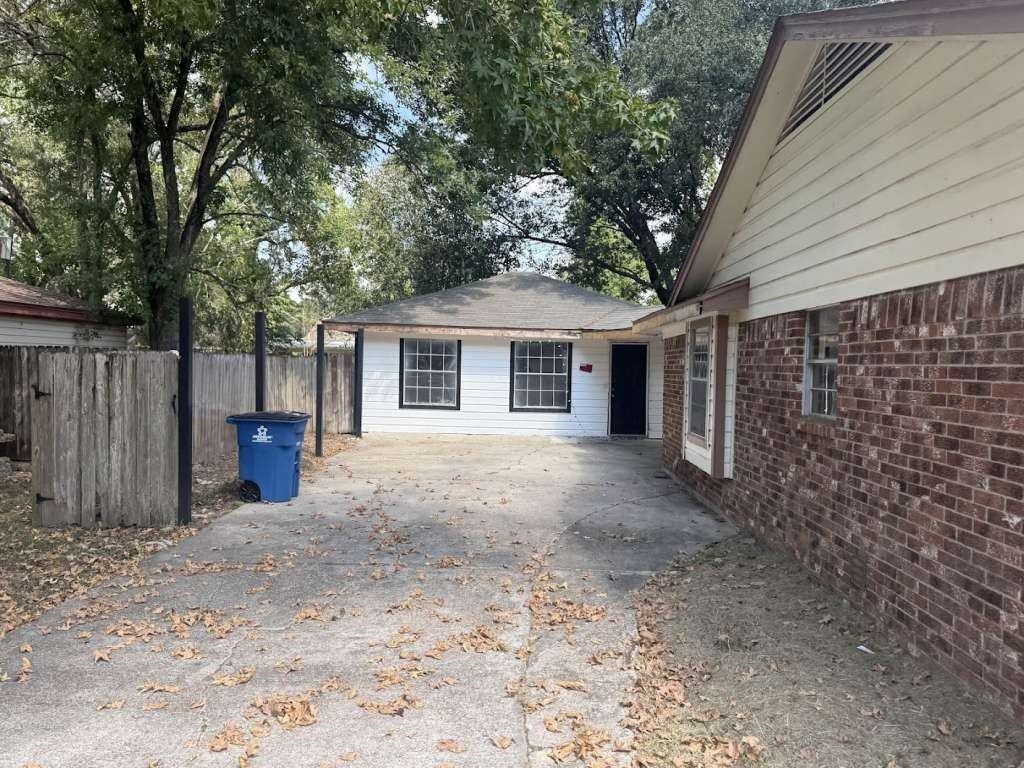 2509 River Ridge Conroe, TX 77385 - Photo 10 of 11 a view of a house with large tree and wooden fence