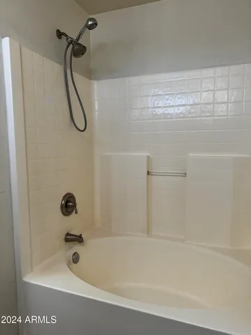 a bathroom with a granite countertop bathtub shower and toilet