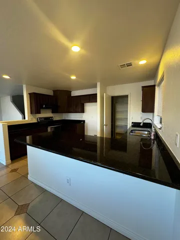 a large kitchen with granite countertop a large counter top and appliances