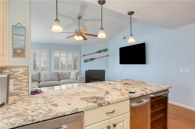 a kitchen with granite countertop a sink cabinets and stainless steel appliances