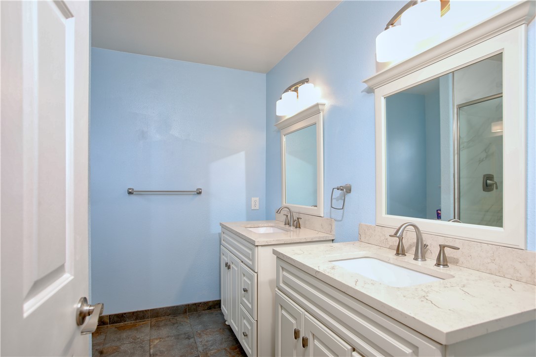 461 Brighton Avenue Grover Beach, CA 93433 - Photo 23 of 46 Remodeled primary bathroom with dual vanity sinks, tiled floor and spacious tiled shower.
