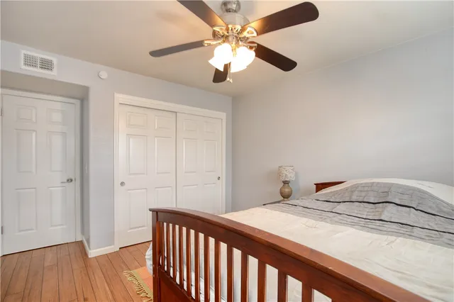 a bedroom with a bed and a flat tv screen on dresser