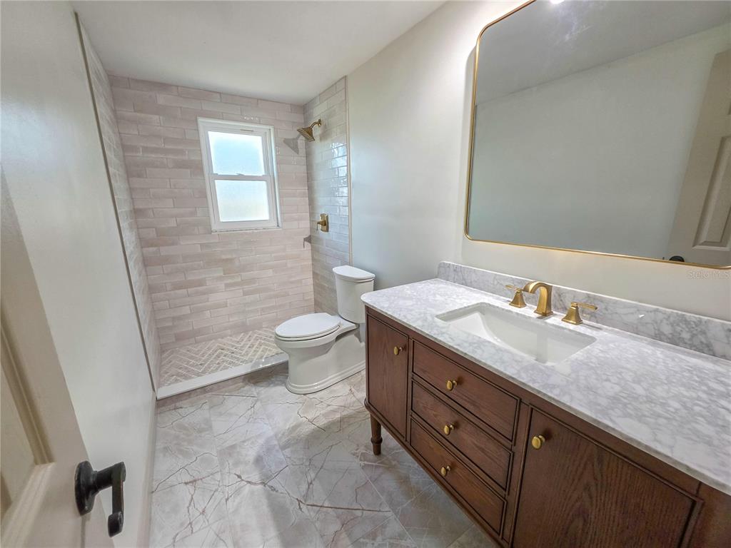 505 Red Mangrove Lane Apollo Beach, FL 33572 - Photo 16 of 24 a bathroom with a granite countertop sink a toilet and a mirror