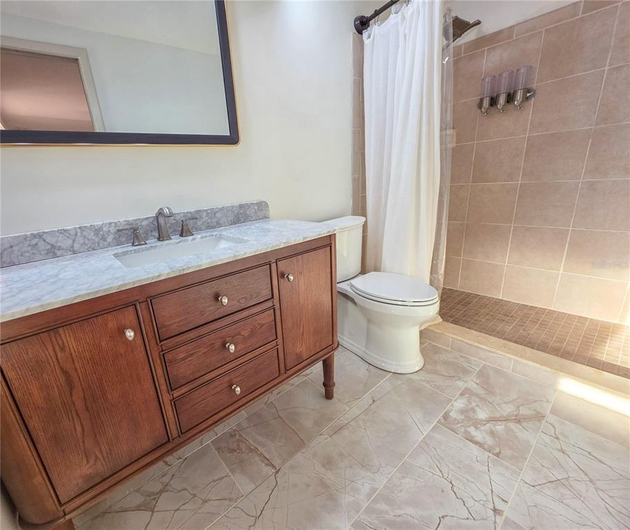 505 Red Mangrove Lane Apollo Beach, FL 33572 - Photo 20 of 24 a bathroom with a granite countertop toilet sink and mirror