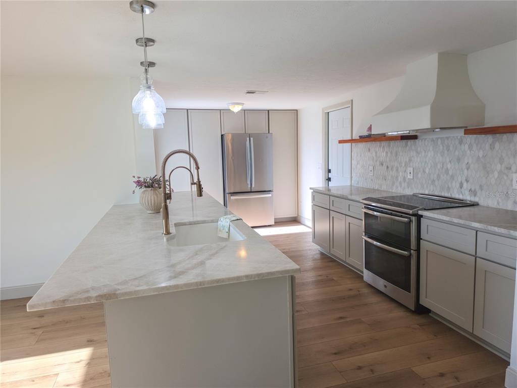 505 Red Mangrove Lane Apollo Beach, FL 33572 - Photo 3 of 24 a kitchen with stainless steel appliances granite countertop a sink a stove and a refrigerator