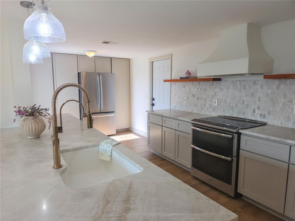 505 Red Mangrove Lane Apollo Beach, FL 33572 - Photo 6 of 24 a kitchen with a sink and a stove top oven