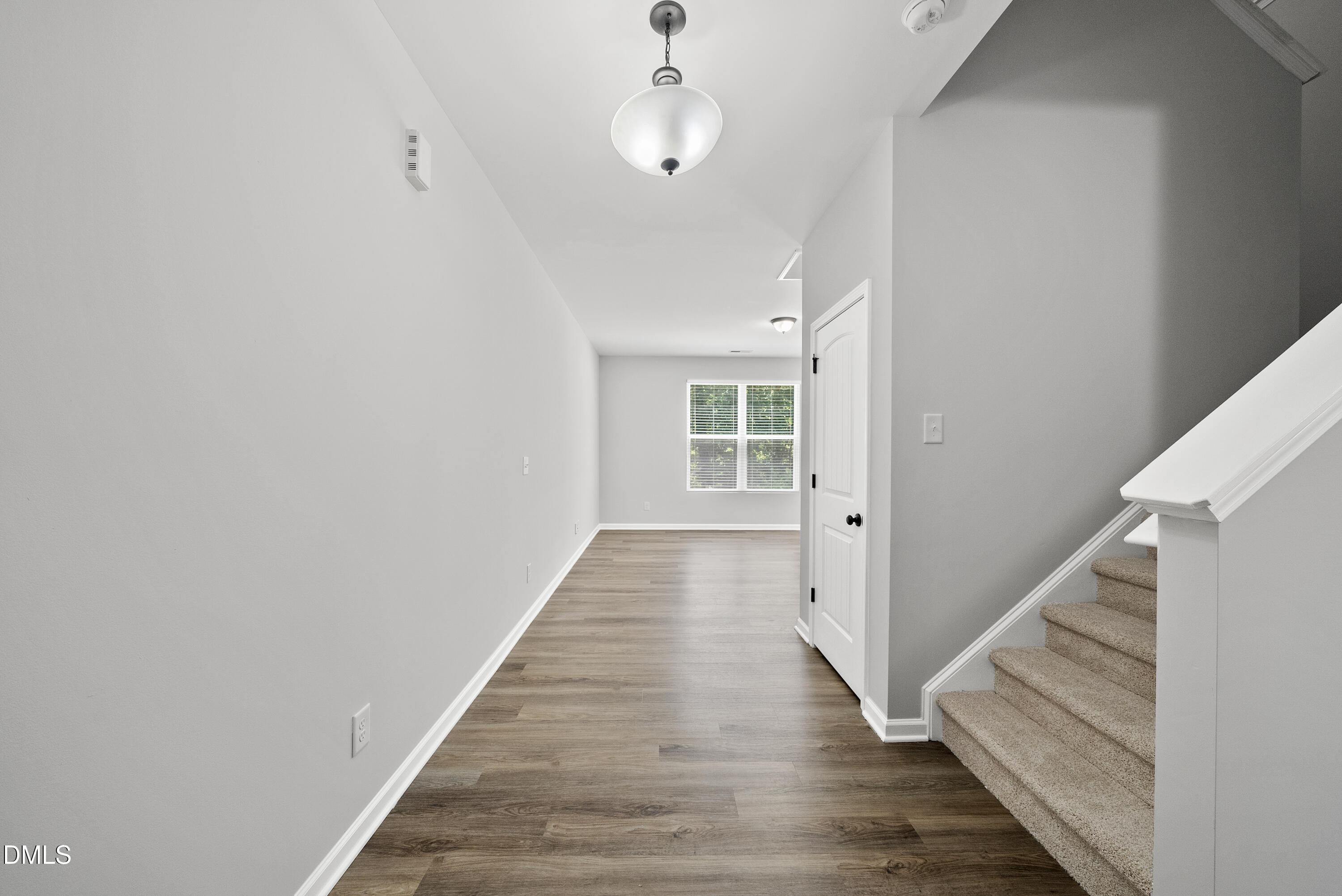 2816 Elsa Drive Raleigh, NC 27610 - Photo 9 of 35 a view of a hallway with wooden floor and staircase