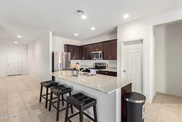 a kitchen with a sink and chairs
