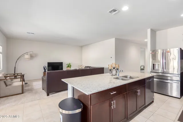 a living room with a couch and a kitchen view