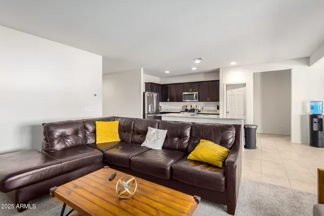 a living room with furniture kitchen view and a window