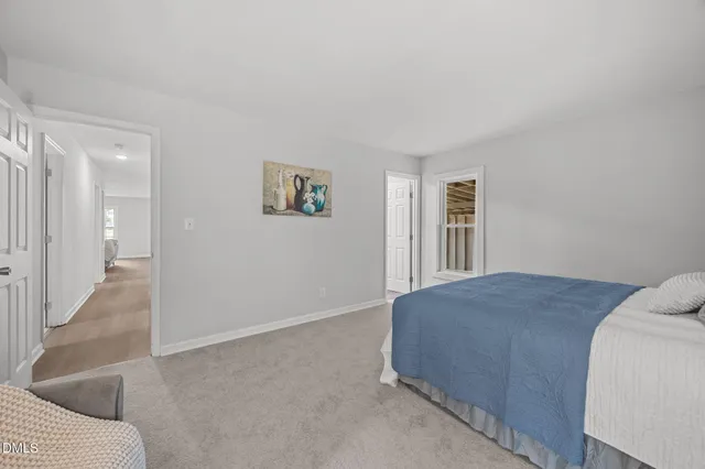 a bedroom with a bed and painting on the wall