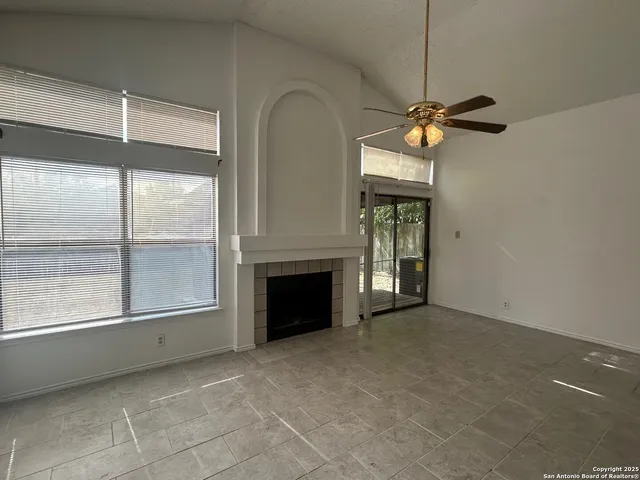a view of an empty room with a fireplace and a window