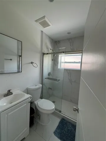 a bathroom with a toilet a sink and shower