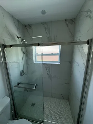 a bathroom with a glass door shower