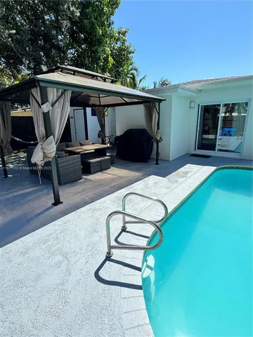 a view of a patio with table and chairs with wooden floor and fence