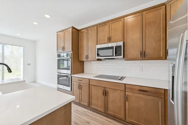 a kitchen with stainless steel appliances granite countertop a stove a sink and a microwave