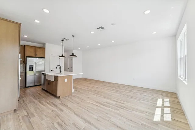 a large kitchen with a lot of counter space and wooden floor