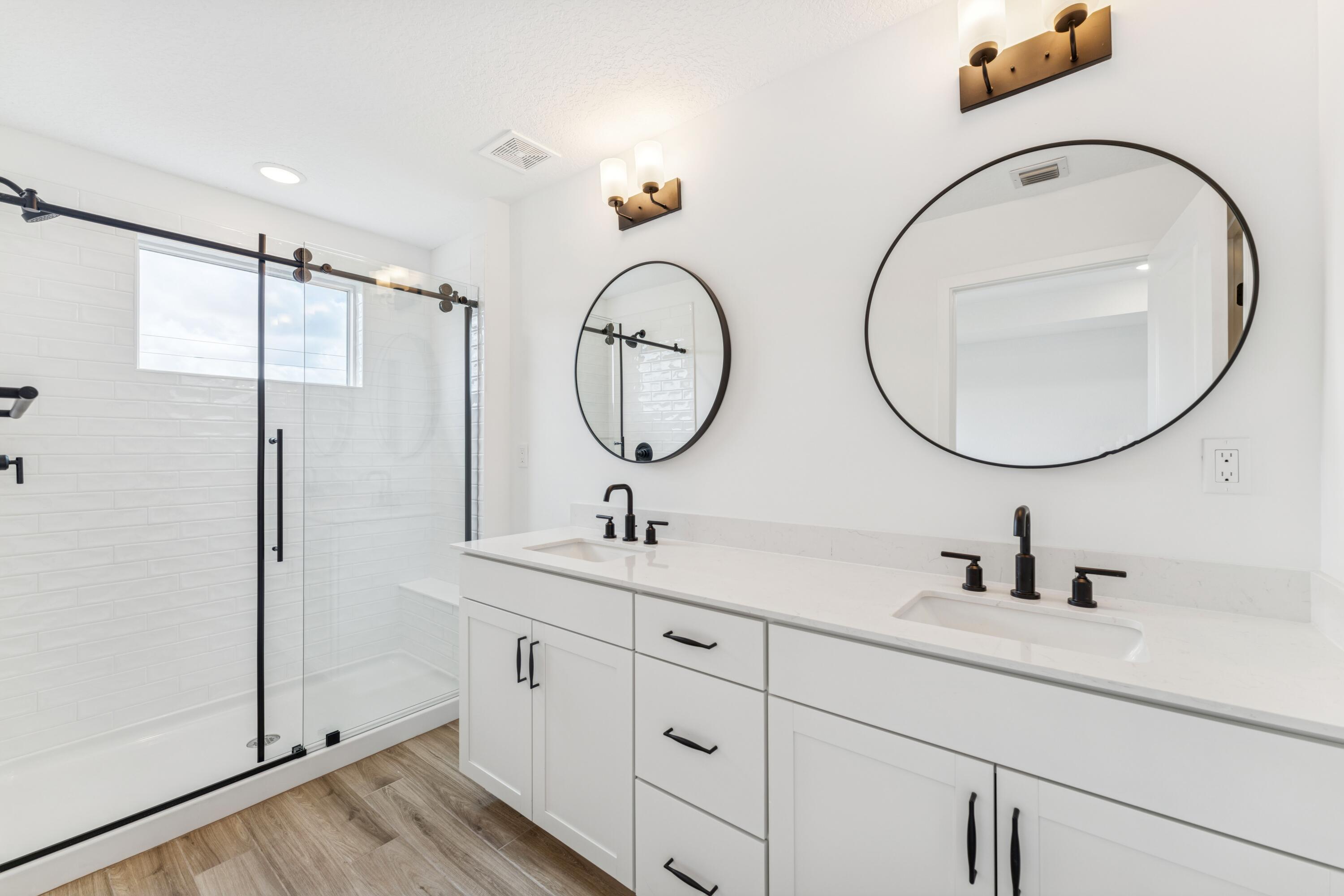 164 Southeast Birch Terrace, Unit 103 Stuart, FL 34997 - Photo 25 of 29 a bathroom with a double vanity sink and a mirror