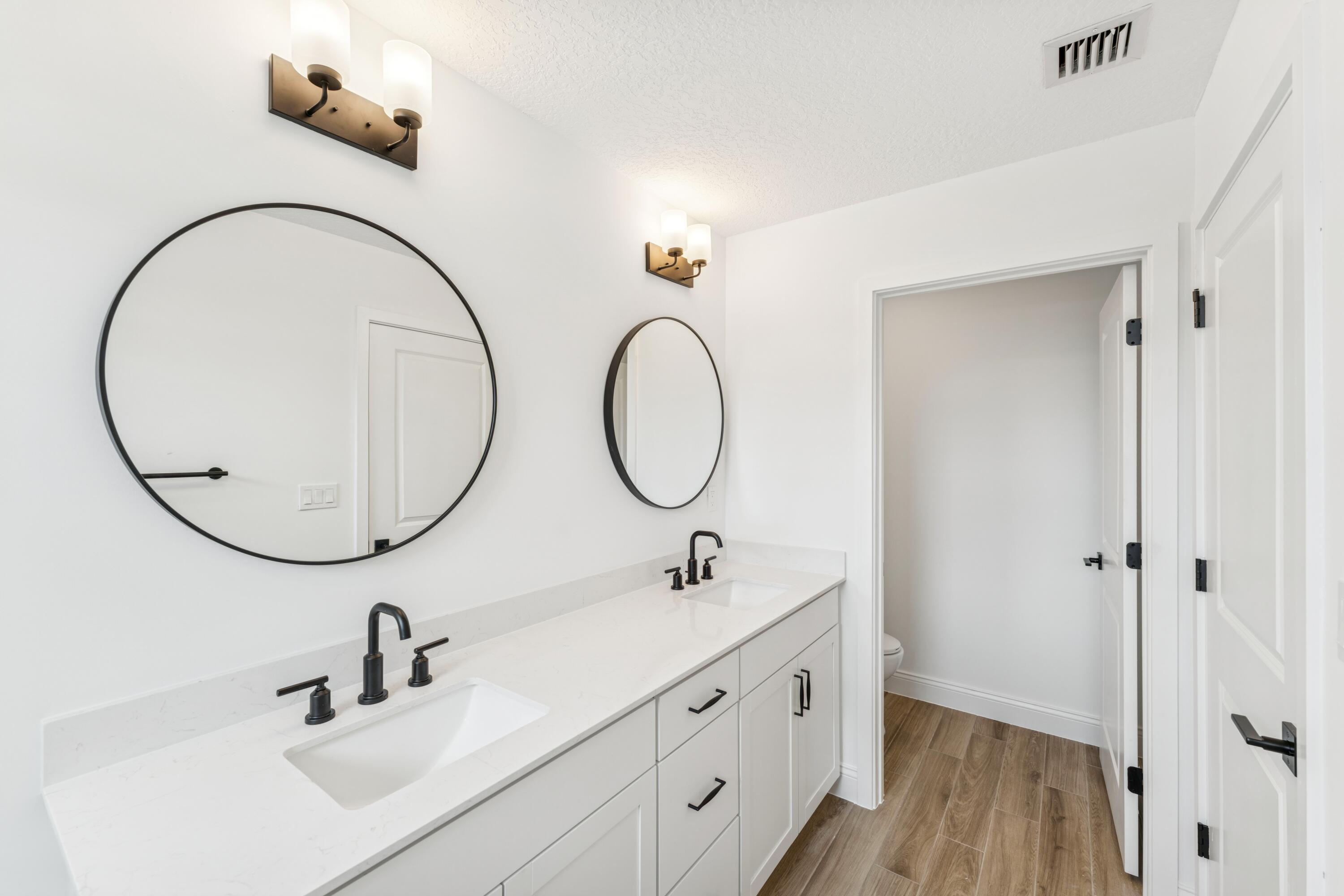 164 Southeast Birch Terrace, Unit 103 Stuart, FL 34997 - Photo 26 of 29 a bathroom with a double vanity sink and a mirror