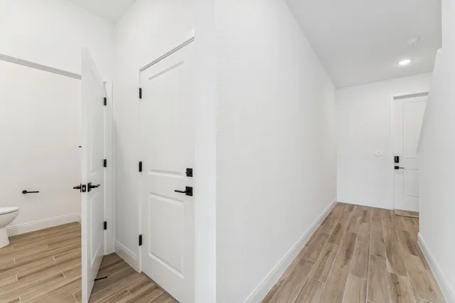 a view of a hallway with wooden floor and staircase