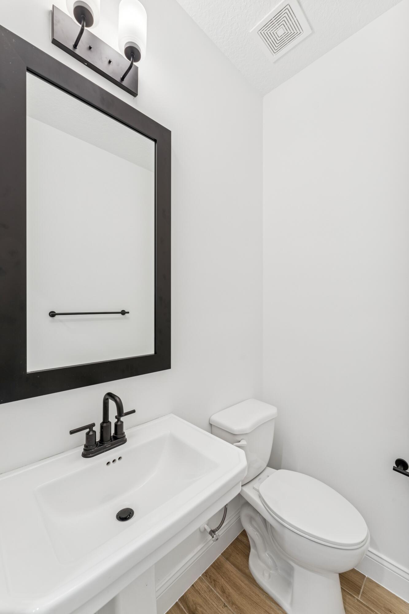 164 Southeast Birch Terrace, Unit 103 Stuart, FL 34997 - Photo 4 of 29 a bathroom with a sink a mirror and a toilet