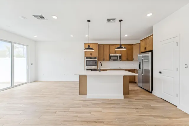 a kitchen with kitchen island a counter top space appliances and a ceiling fan