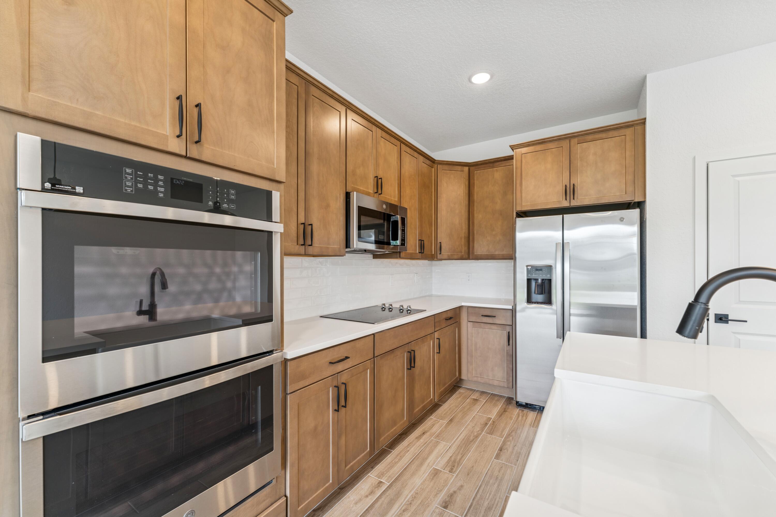164 Southeast Birch Terrace, Unit 103 Stuart, FL 34997 - Photo 9 of 29 a kitchen with stainless steel appliances kitchen island granite countertop a stove microwave and refrigerator