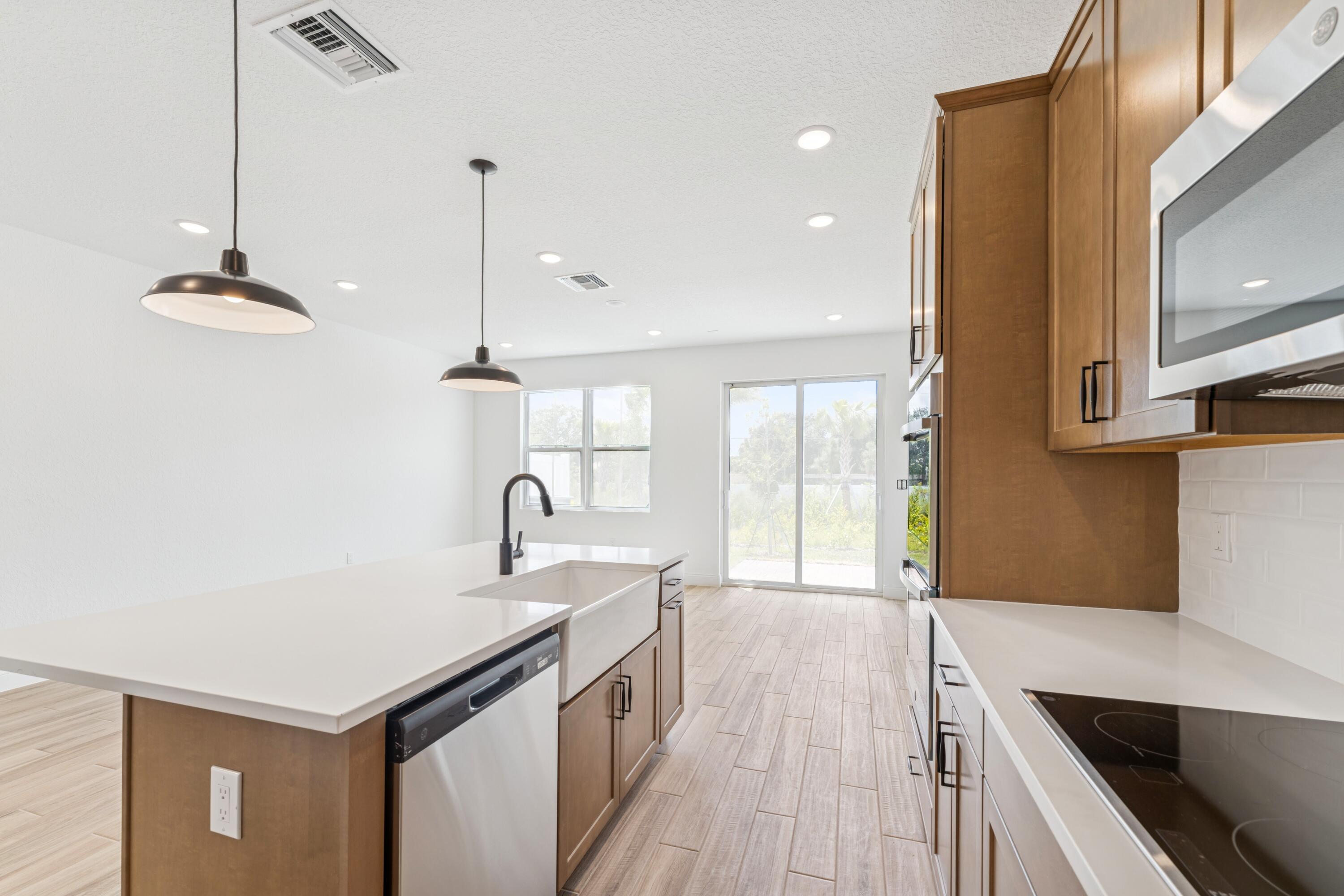 164 Southeast Birch Terrace, Unit 103 Stuart, FL 34997 - Photo 10 of 29 a kitchen with stainless steel appliances granite countertop a sink a stove and a wooden floors