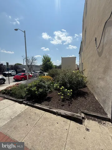 a view of a street with potted plants