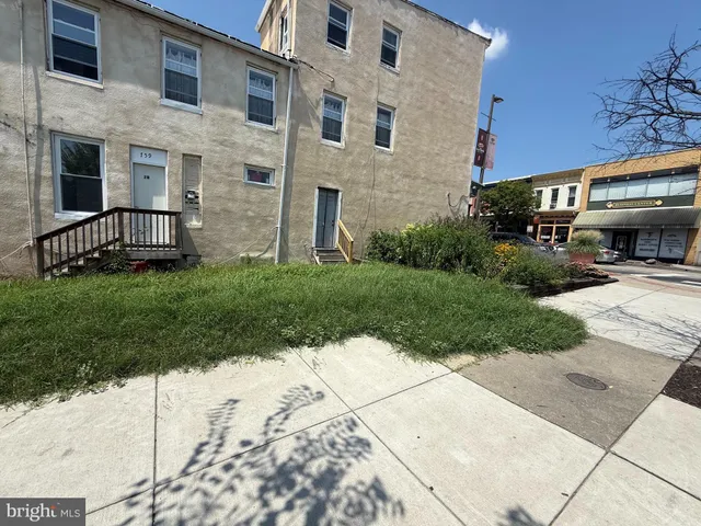 a view of a brick house with a yard and plants