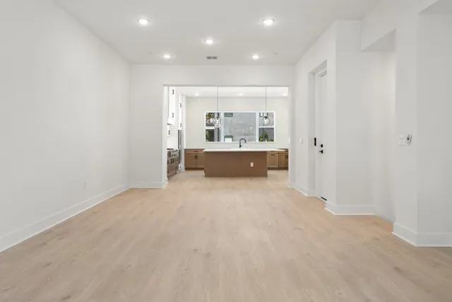 a large kitchen with stainless steel appliances sink a stove and cabinets