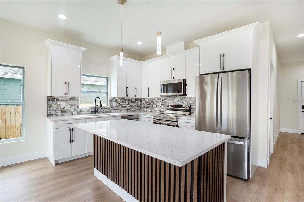 3612 Temple Street Tampa, FL 33619 - Photo 11 of 26 a kitchen with refrigerator cabinets and wooden floor
