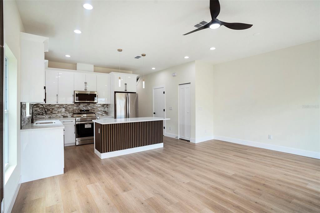 3612 Temple Street Tampa, FL 33619 - Photo 9 of 26 a kitchen with stainless steel appliances kitchen island granite countertop a refrigerator a stove a sink and a oven with wooden floor