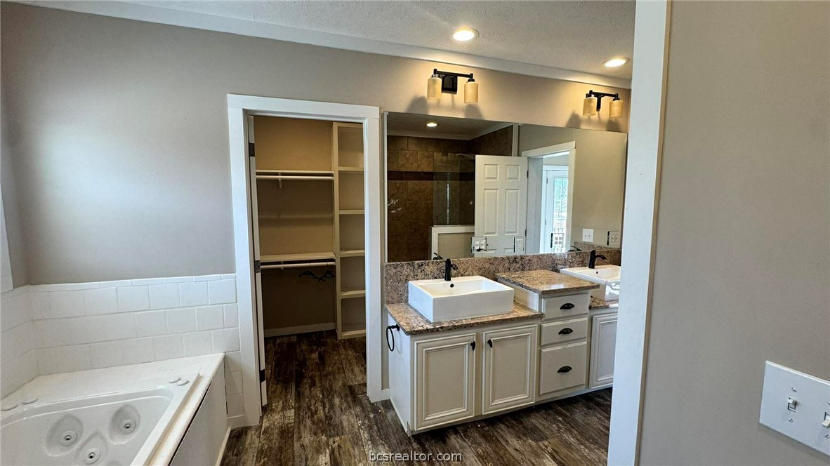 100 Patriots Place Somerville, TX 77879 - Photo 6 of 28 a bathroom with a double vanity sink a toilet and a tub