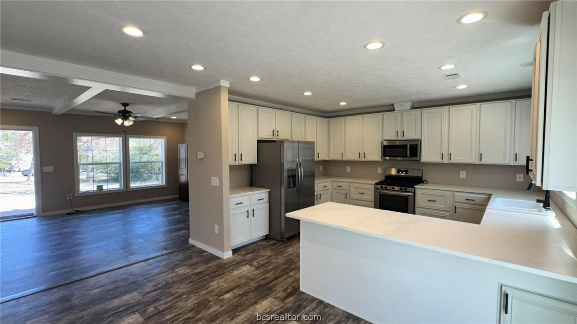 100 Patriots Place Somerville, TX 77879 - Photo 8 of 28 a kitchen with granite countertop a stove top oven a sink a refrigerator a counter top space and cabinets
